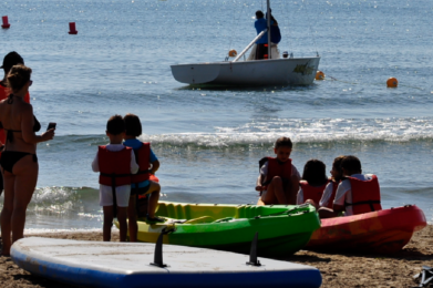 Foto de niños aprendiendo a realizar actividades náuticas en la playa de San Juan